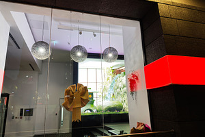 Bright modern store window in Manchester featuring a large gold bow and decorat, a Photo by AS photostudio