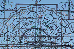 Ornamental iron gate against clear blue sky, an Architecture Photo by DanFLCreativo