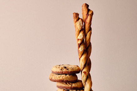 A stack of chocolate-covered biscuits and cookie sticks on beige