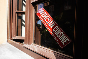 Indonesian cuisine sign on a closed window in bright natural light, a Photo by AS photostudio