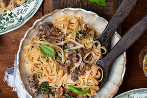 Plate of pasta with forest chanterel containing food, parsley, and pasta