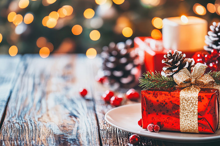 Red Christmas gifts with golden bows, pinecones, and festive bokeh lights on wo, a Holiday Photo by Mashimara