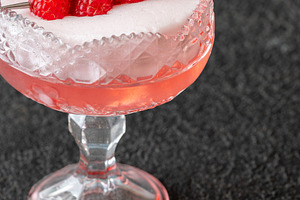 Elegant Clover Club cocktail with velvety foam fresh raspberries