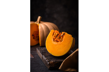 Raw fresh cut pumpkin on dark
