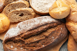 Fresh baked bread, baguettes, buns, and flour on concrete, a Food & Drink Photo by Olena Rudo