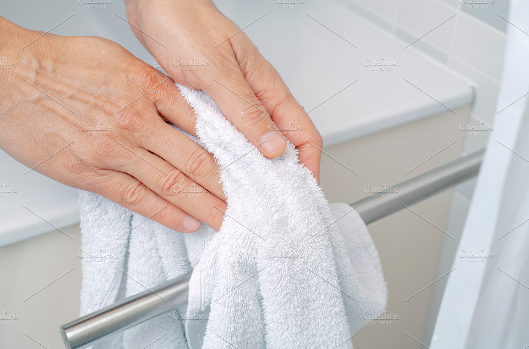 a man drying hands with a towel in a bathroom, a Photo by Nito