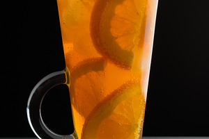 A drink with orange slices in a tall glass on a black table, a Food & Drink Photo by ndanko