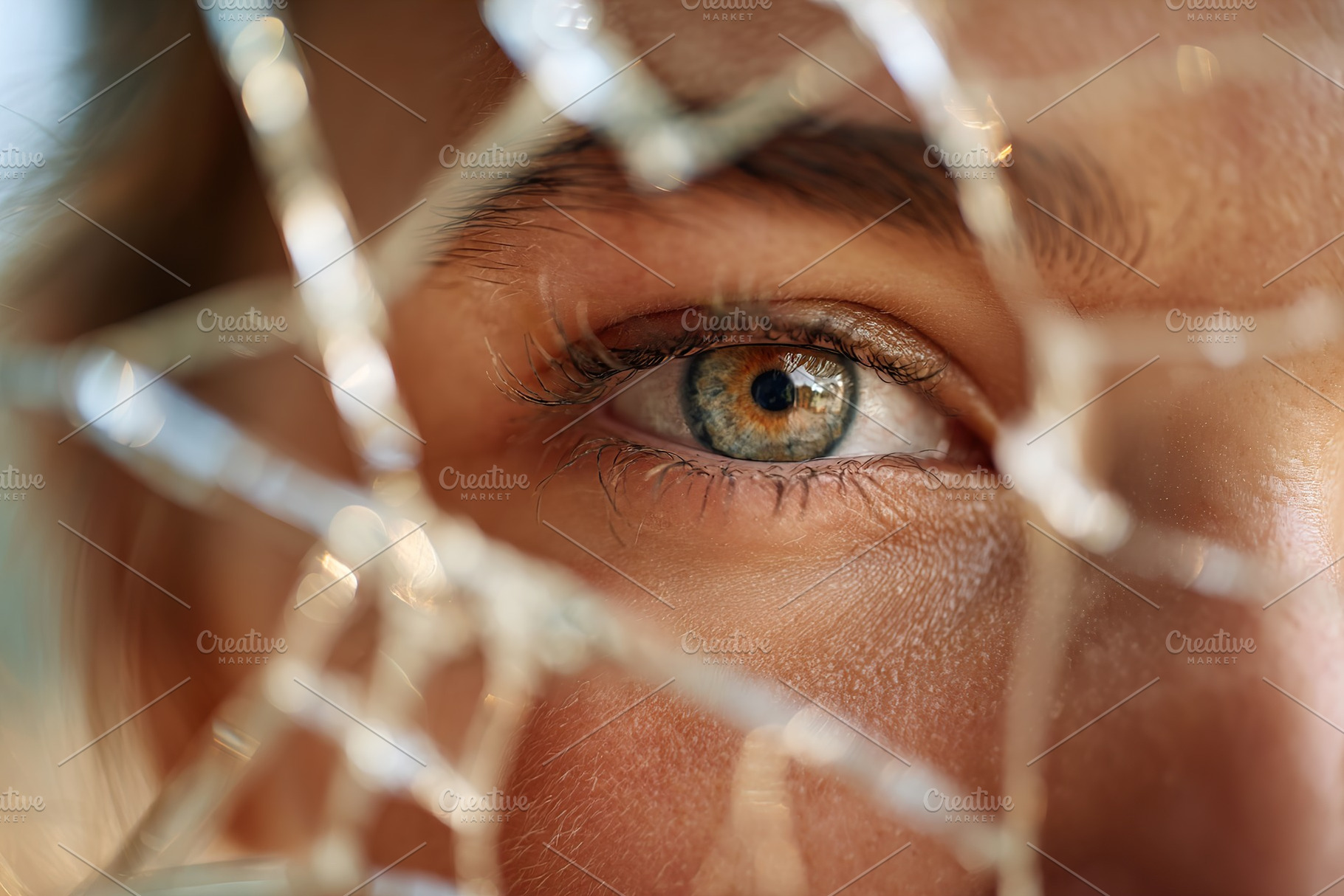 Intense close-up of a woman's eye seen through shattered glass during daylight, a Background Photo by AlyaAnd