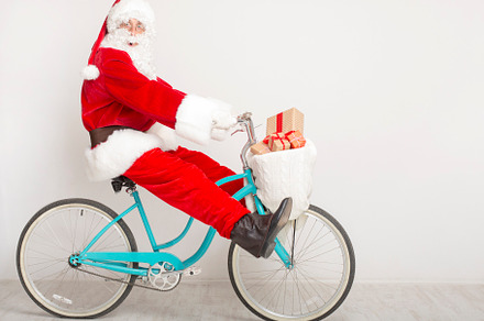 Santa fooling on bike trying to deli, a Background Photo by Prostock-Studio