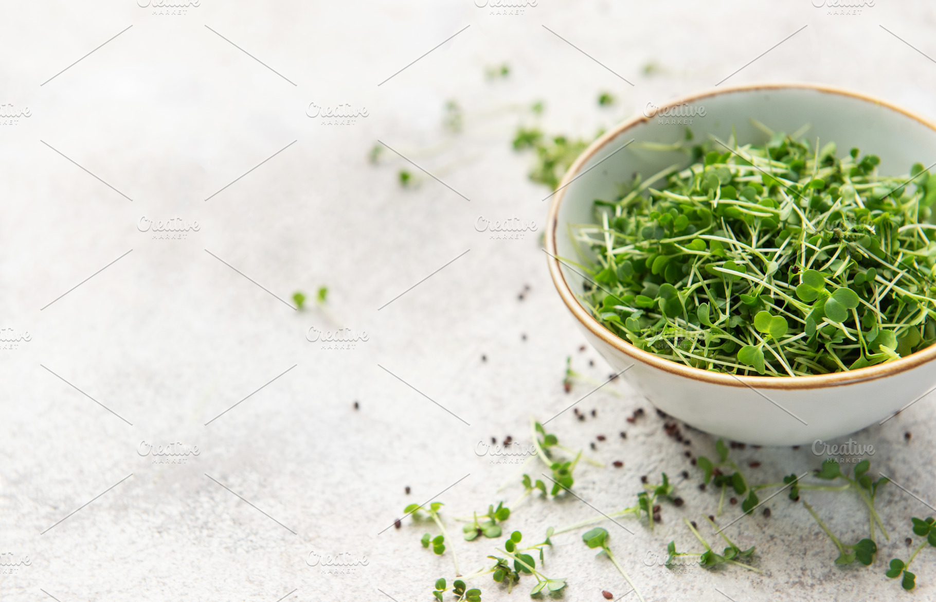 Fresh green microgreens in a bowl on a light surface, a Food & Drink Photo by Olena Rudo