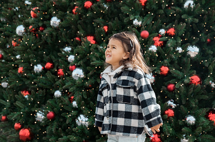 Toddler girl against Christmas tree