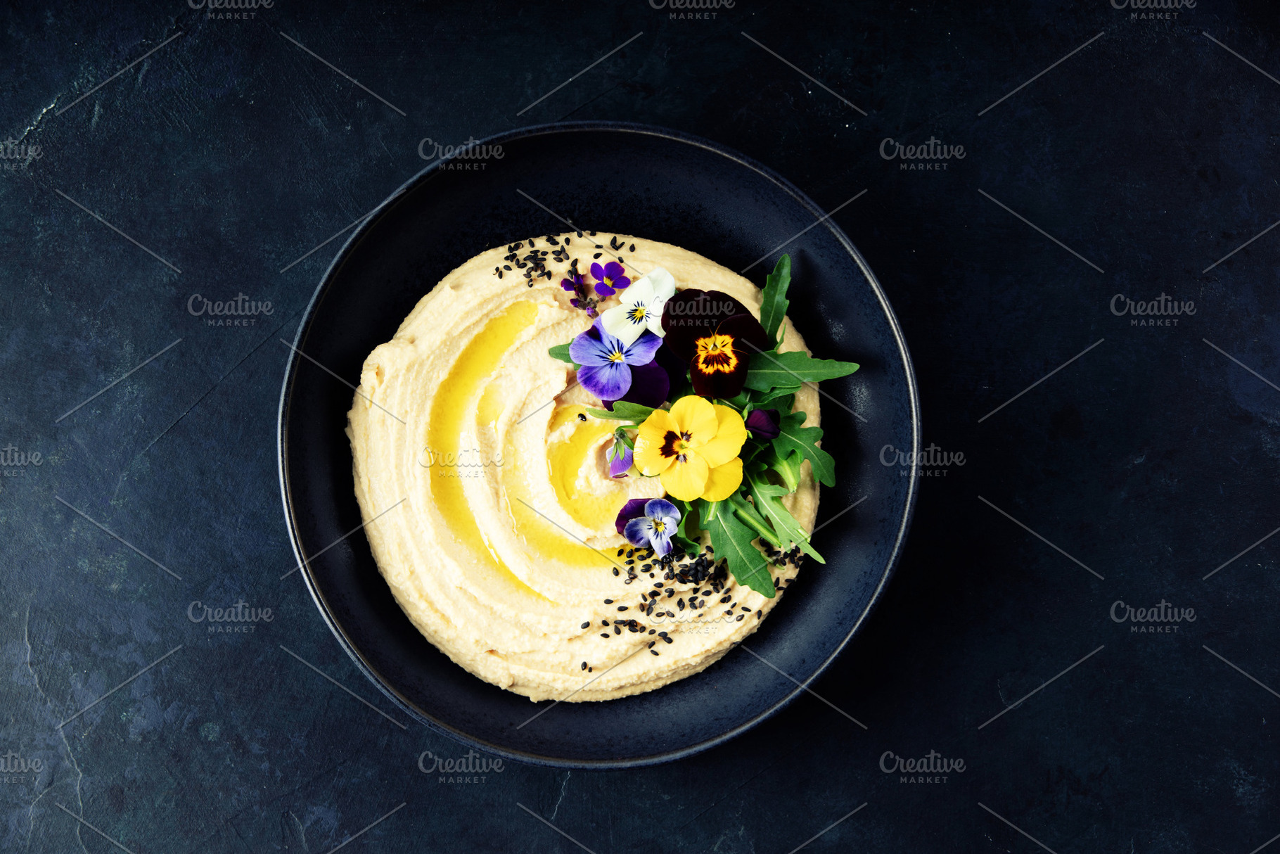 Elegant Hummus with Edible Flowers and Olive Oil on Dark Plate, a Food & Drink Photo by Natalia Klenova's Shop