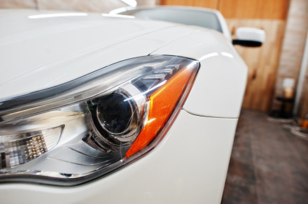 Headlight of white new luxury sport car in detailing garage., a Transportation Photo by AS photostudio