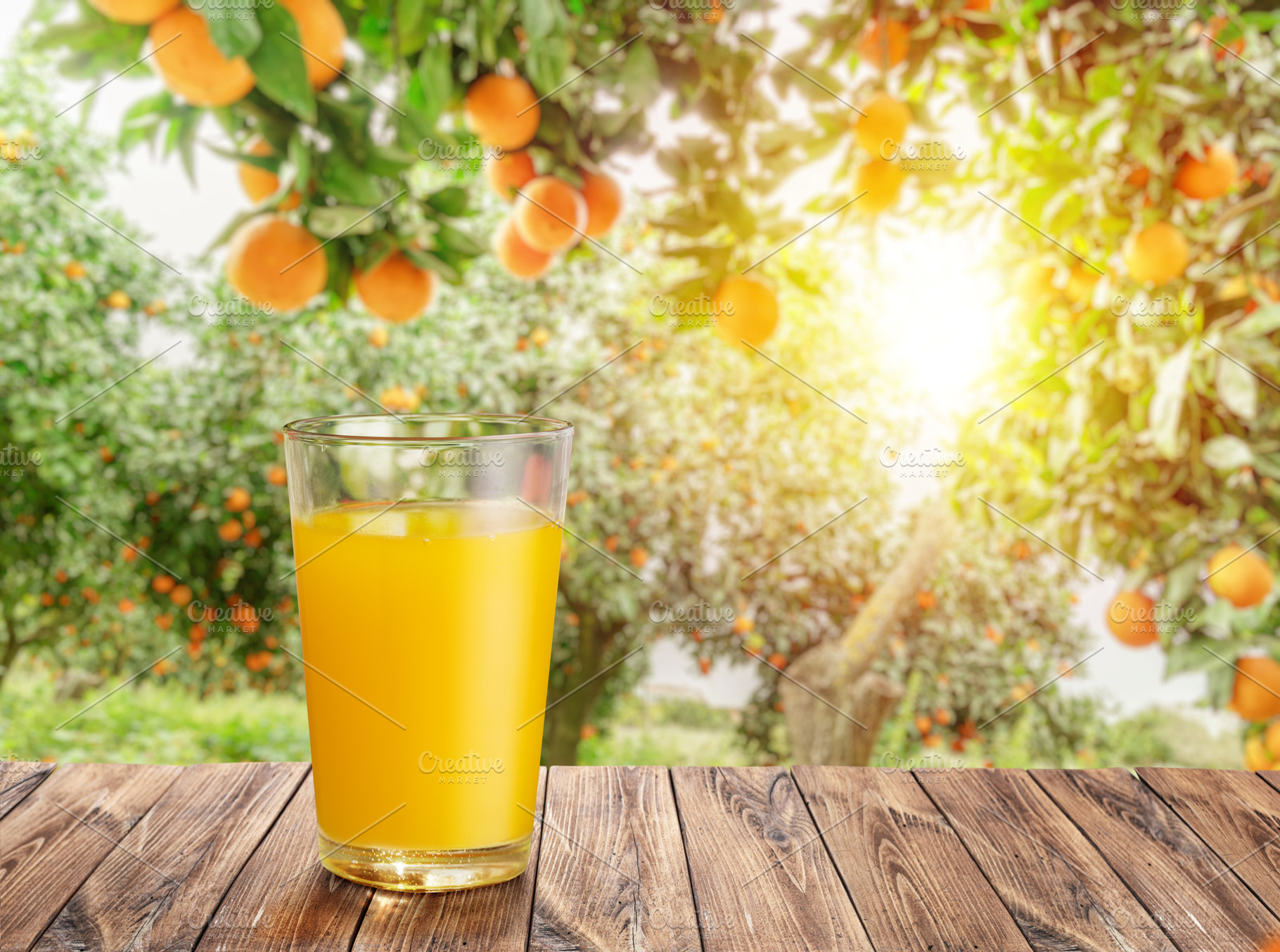 Glass of orange juice on wooden board or table top and blurred o, a Food & Drink Photo by Volff