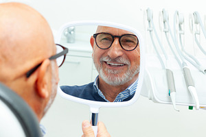 Senior patient admiring his smile after dental procedure, a Health & Medical Photo by Antonio Gravante Market