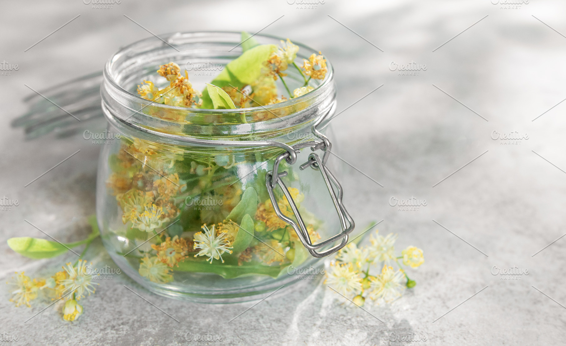 Linden blossoms filling glass jar for herbal medicine, a Food & Drink Photo by Olena Rudo