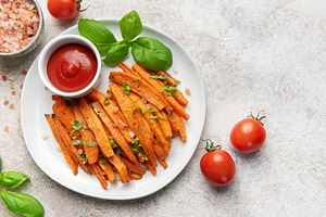 Sweet potato fries with ketchup and basil leaves, a Food & Drink Photo by Olena Rudo