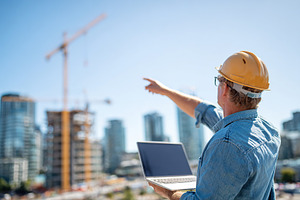 Young male architect directs construction work while demonstrating design ideas, an Industrial Photo by AlyaAnd