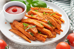Sweet potato fries with ketchup and basil leaf, a Food & Drink Photo by Olena Rudo
