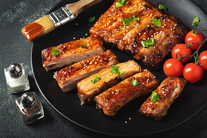 Hot grilled spare ribs from a summer BBQ served on a plate with, a Food & Drink Photo by Budarinphoto