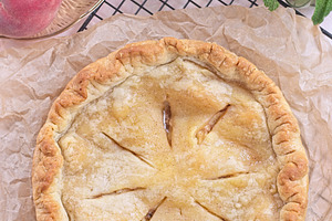 Freshly baked old fashioned deep dish peach pie cooling on baking rack, vertica, a Food & Drink Photo by iuliia_n