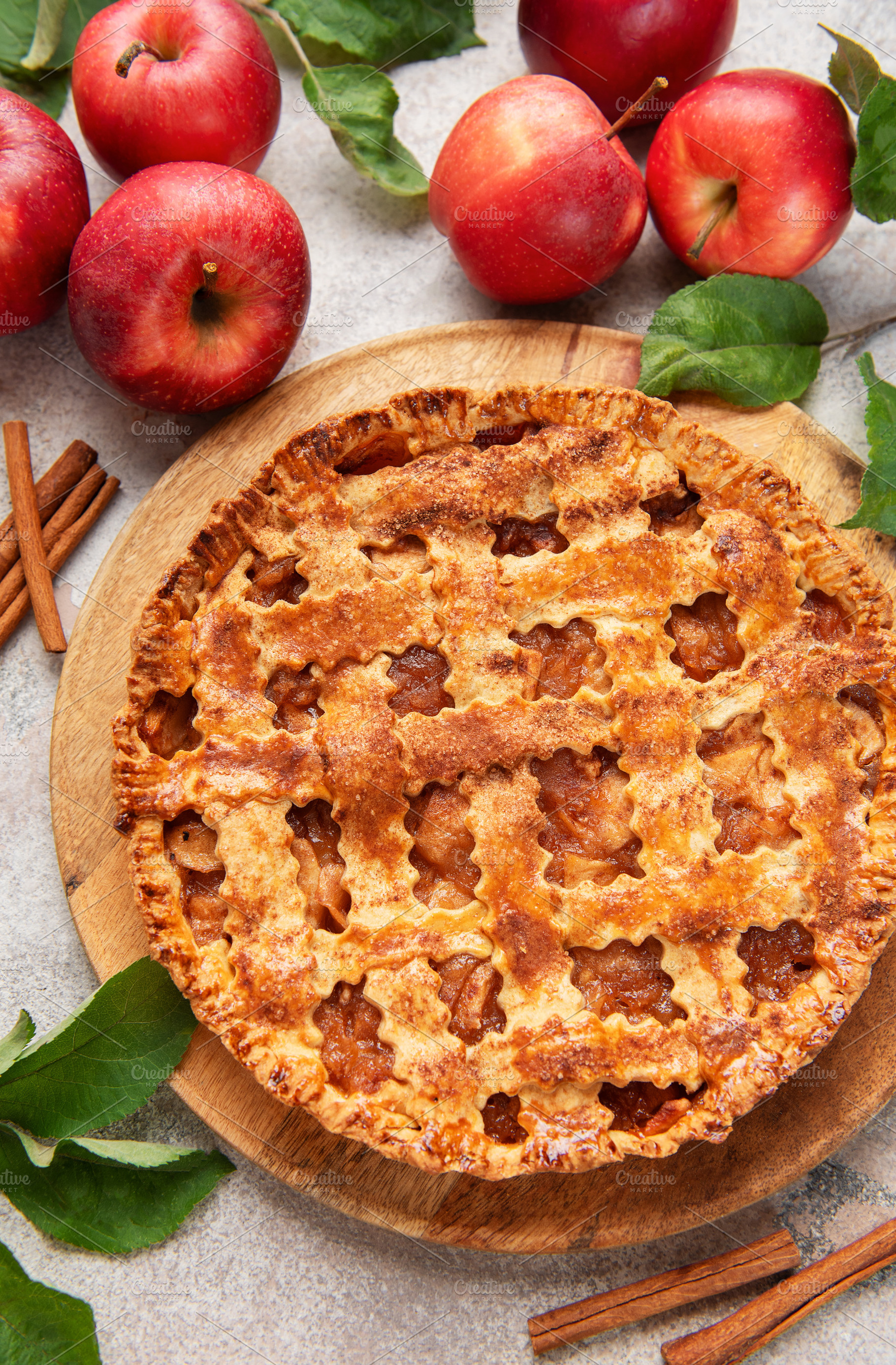 Freshly baked apple pie decorated with cinnamon sticks and apple, a Food & Drink Photo by Olena Rudo