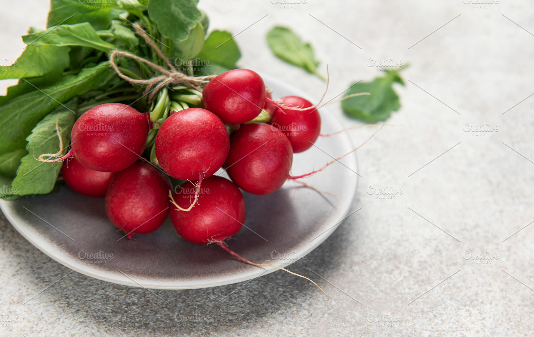 Fresh red radishes with green leaves on plate, a Food & Drink Photo by Olena Rudo