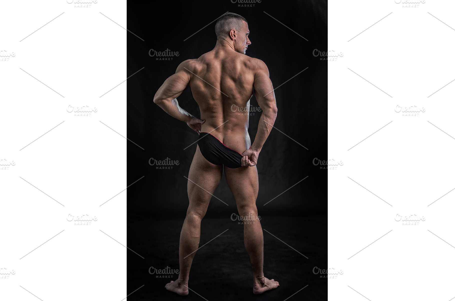 Muscular man pulling down underwear, a Person Photo by ArtOfPhotos photo store