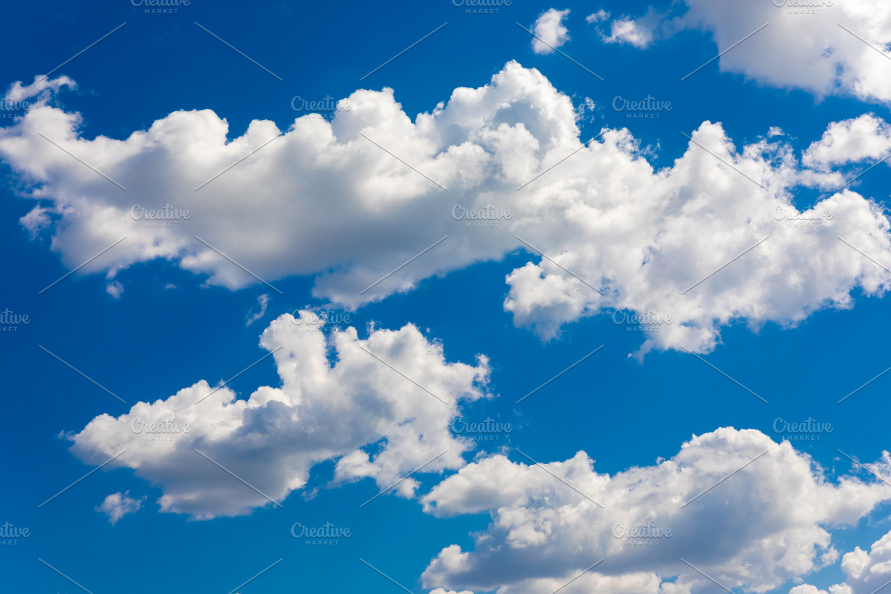 White cumulus clouds scattered across a deep blue sky on a sunny, a Nature Photo by Ales Munt