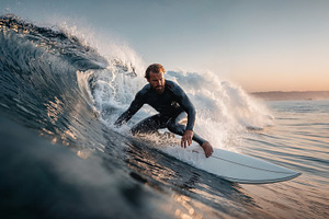 Surfer rides wave during golden hour on beach coastline, a Sports & Recreation Photo by OSORIOartist