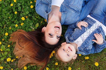 Mother and daughter lying on lawn featuring flower, background, and family, a Person Photo by Elena Vagengeim