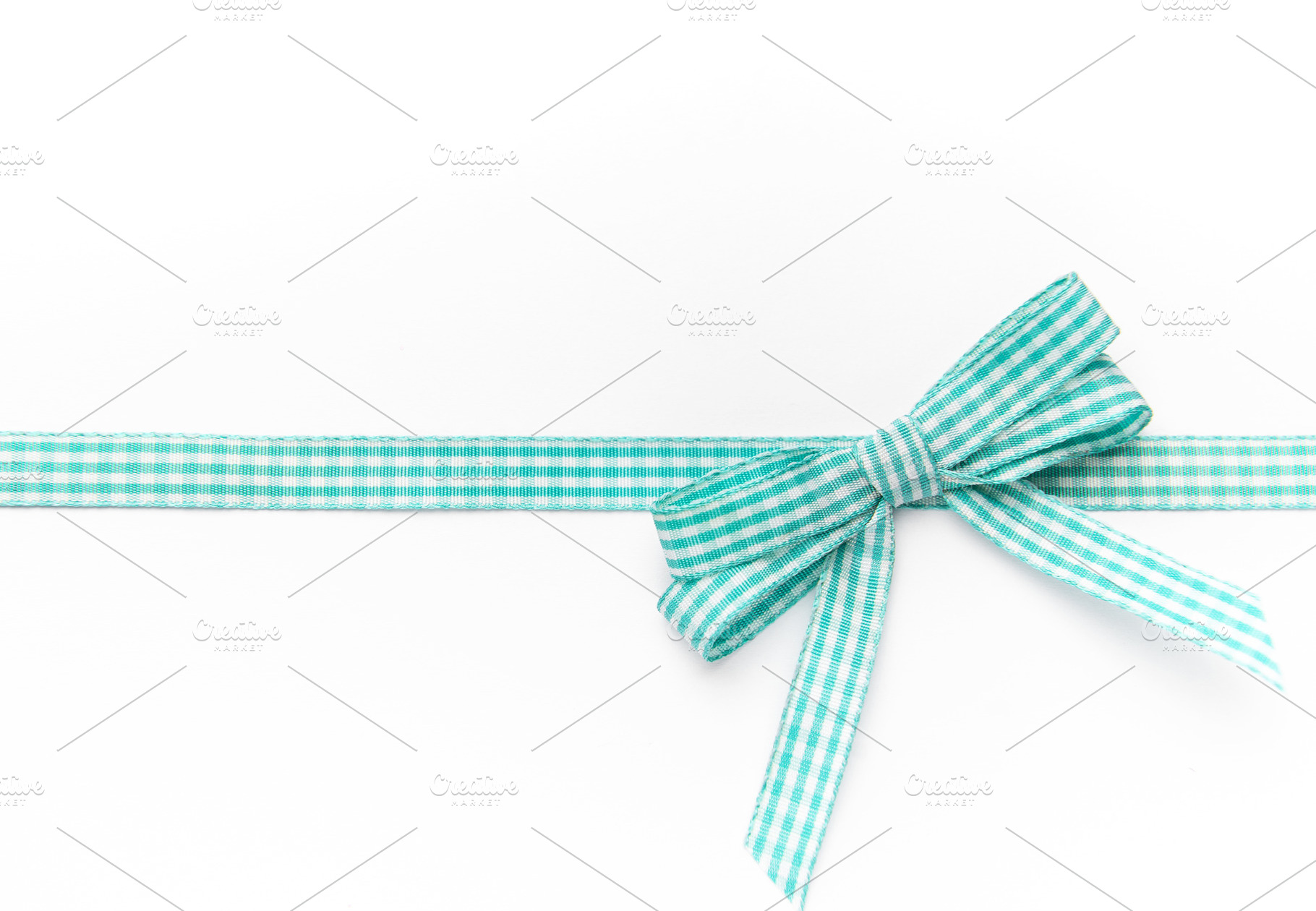 Gingham ribbon forming a gift bow on white background, a Holiday Photo by Olena Rudo