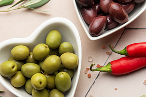 Heart shaped bowls containing green and black olives, olive bran, a Food & Drink Photo by Olena Rudo