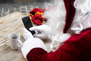 Santa Claus using smartphone while having coffee at outdoor cafe, a Person Photo by etorres69