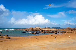 Wide sandy beach overlooking rocky islet in Tregastel, Brittany,, a Nature Photo by GoodGoods