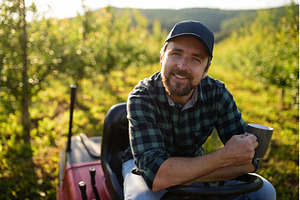 Farmer sitting on small tractor in, a Business Photo by HalfPoint