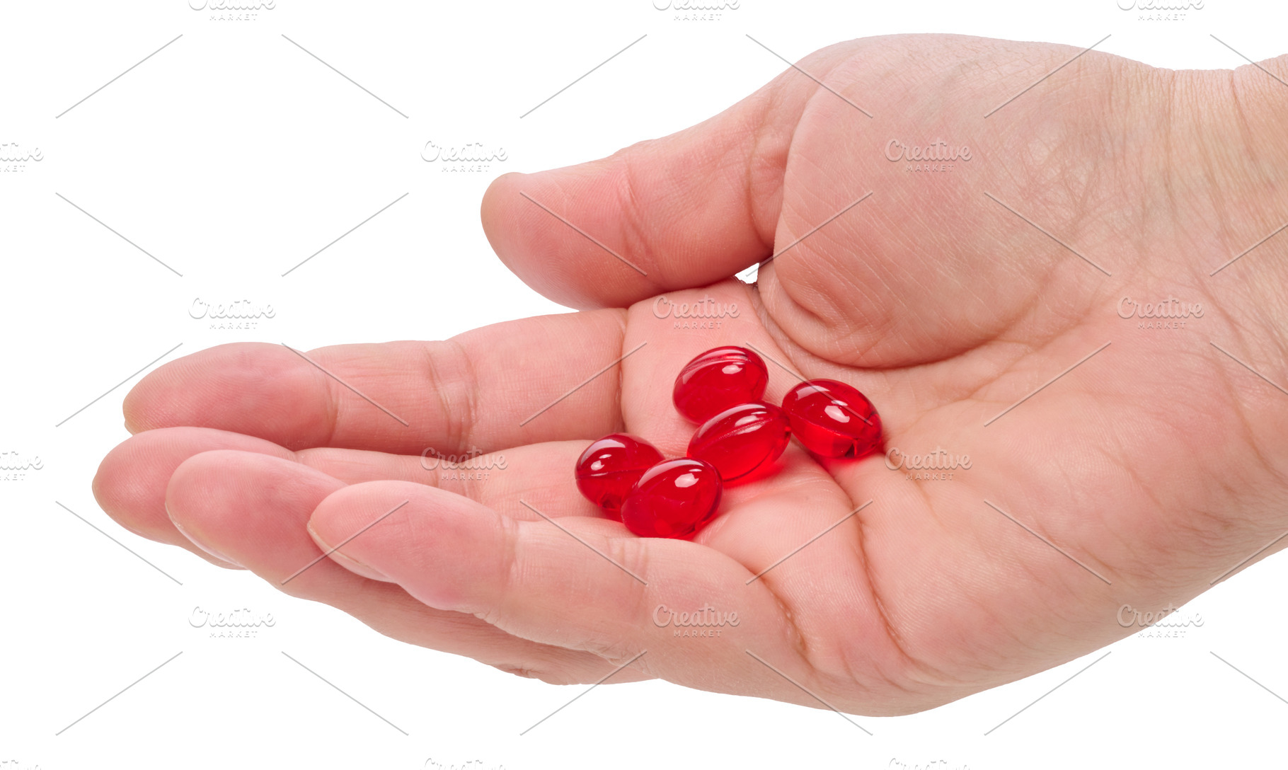 Red gel capsules or vitamins on a person's palm against, a Health & Medical Photo by ndanko