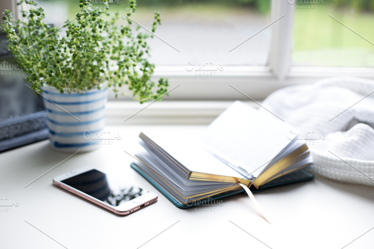Phone and book at window, a Business Photo by the studio louvain shop (Photo 1 of 2)