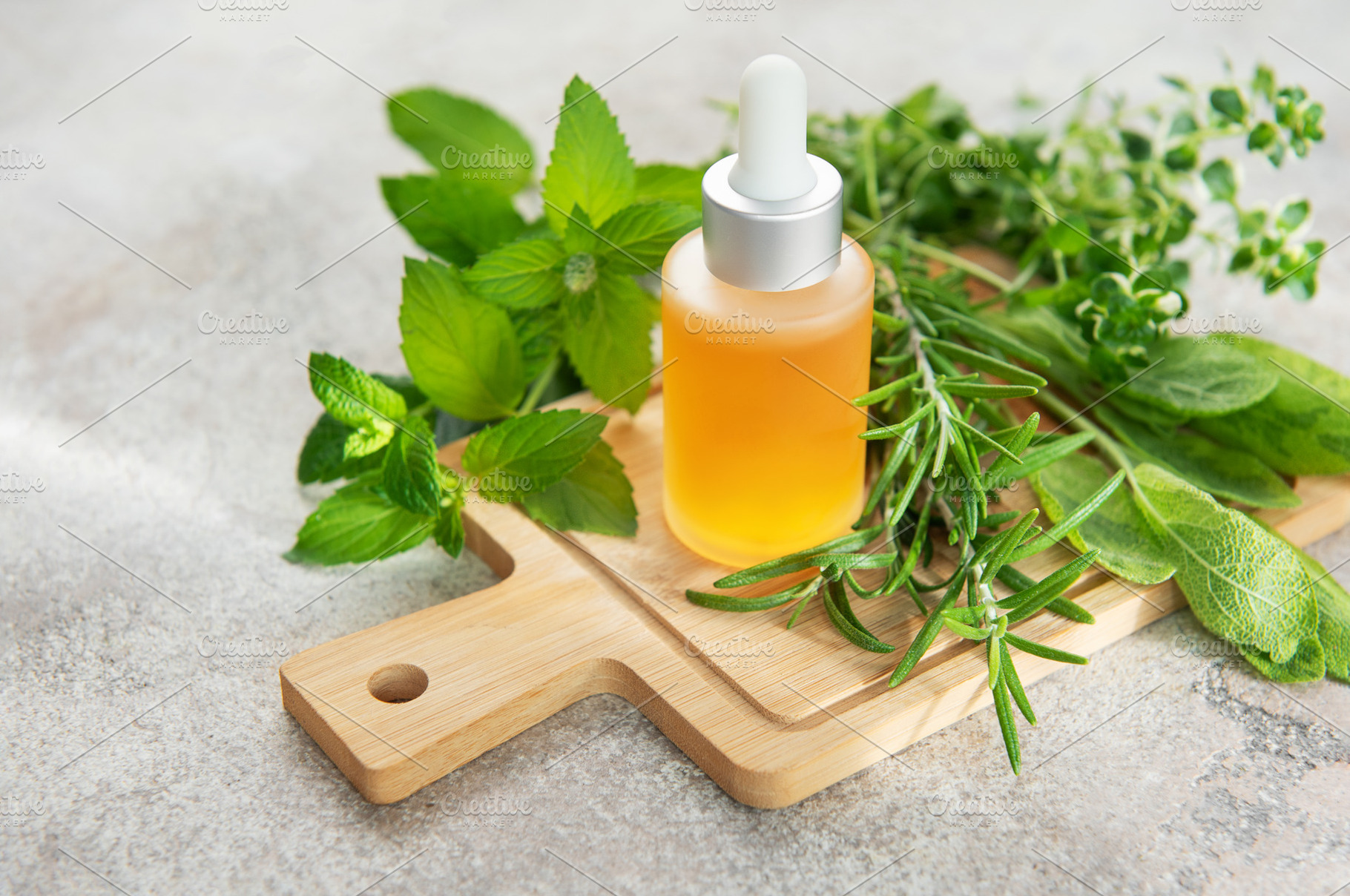 Essential oil bottle with natural herbs and plants on board, a Food & Drink Photo by Olena Rudo