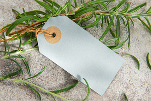 Fresh rosemary sprigs with blank tag on stone background, a Food & Drink Photo by Olena Rudo