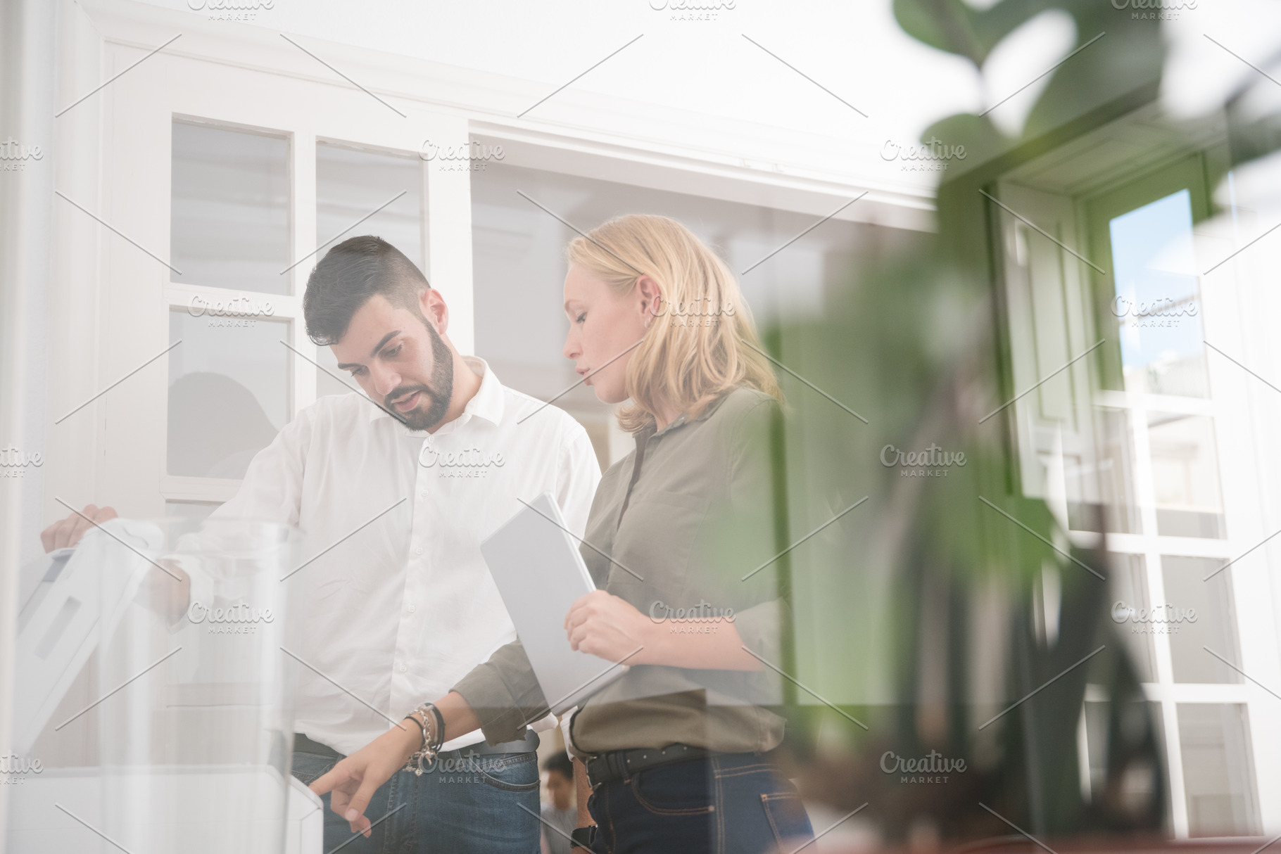 Man and woman in an office using a p stock photo containing man and woman, a Person Photo by Coco Images