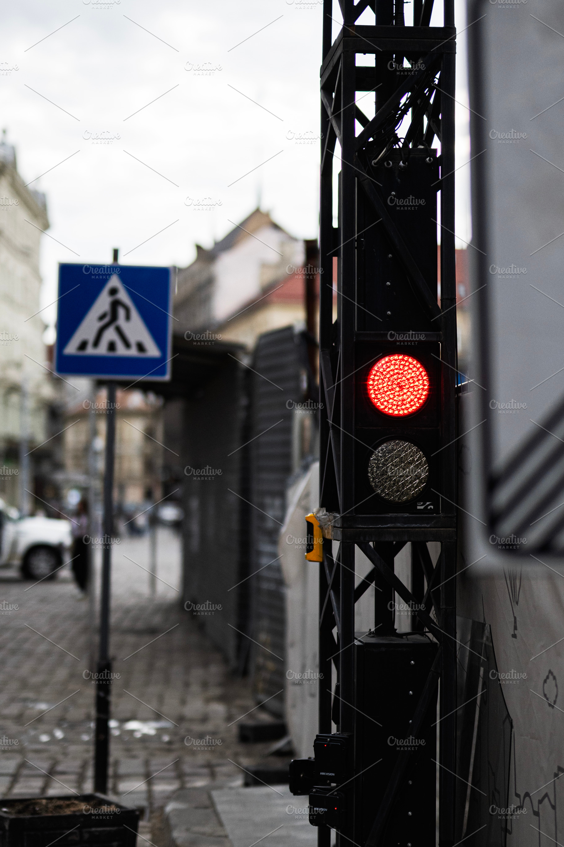 Urban scene with pedestrian crossing and traffic light during overcast weather, a Photo by AS photostudio