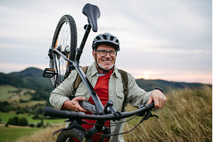 Smiling senior cyclist carrying, a Sports & Recreation Photo by HalfPoint