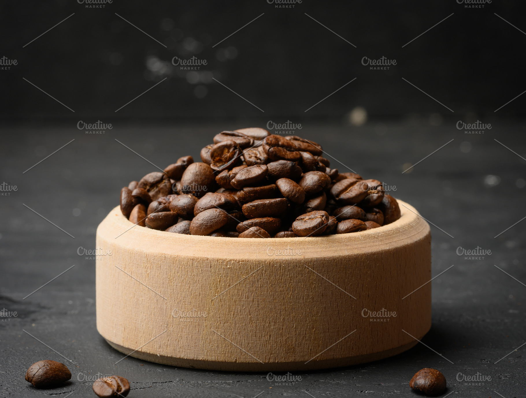 Roasted coffee beans in a wooden bowl on a black background, a Food & Drink Photo by ndanko
