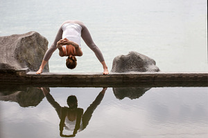 Woman practicing morning meditation yoga at the beach stock photo containing