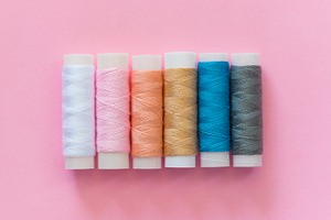 Thread spools with pink background featuring thread, spool, and embroidery