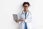 Portrait of black female medical practitioner holding laptop, a Photo by Prostock-Studio (Thumbnail 1 of 2)