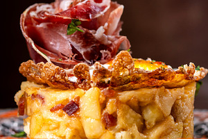 Traditional Spanish potato omelette with Iberian ham and crispy pork rind serve, a Food & Drink Photo by etorres69