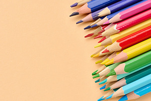 Multicolored wooden pencils stacked on a beige background, a School & Education Photo by ndanko