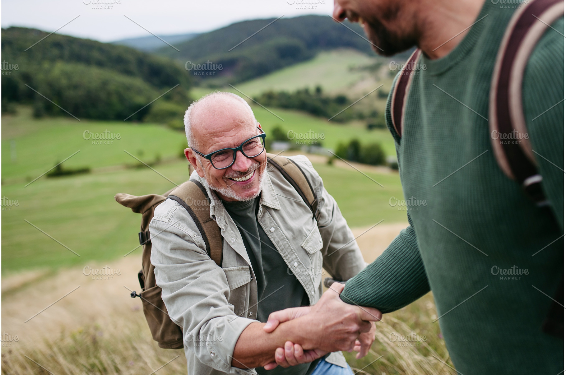 Adult son and older father hiking, a Person Photo by HalfPoint
